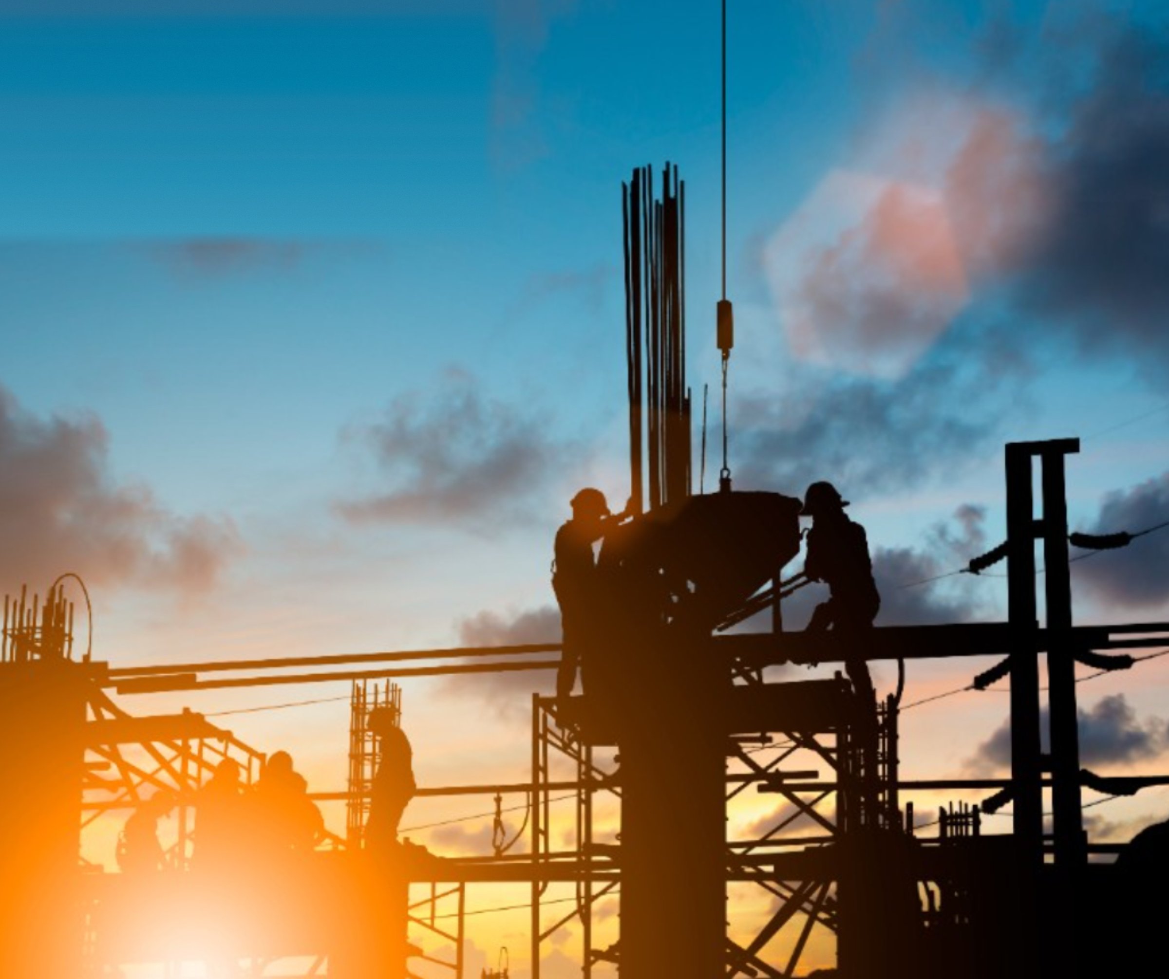 CFI Industries crew working on an industrial construction site at dusk — steel structure assembly, CWB welding and industrial mechanics in Saguenay–Lac-Saint-Jean, Quebec.