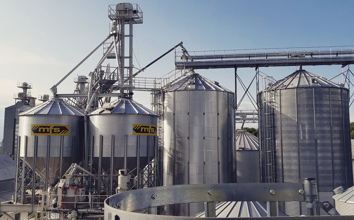 Symaga and GSI commercial grain silo installation by CFI Industries in Quebec — agricultural complex with central elevator, conveyors and hopper-cone silos