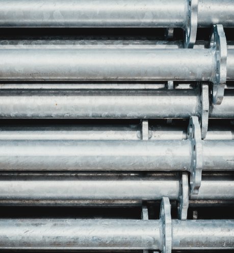 Galvanized steel piping and industrial pipes stacked — parts prepared for mechanical fabrication and CWB welding by CFI Industries in Quebec